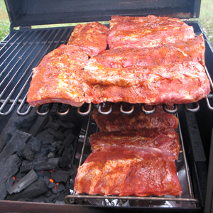 Baby back ribs smoking on the grill